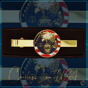 Gold-tone tie clip. Features a police emblem design on a red, white,