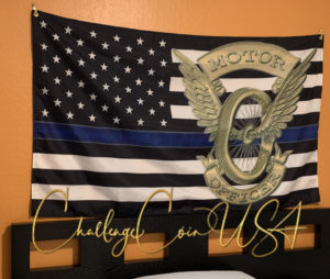 Thin Blue Line flag with a motor officer emblem. Blue, black, and white stripes. Challenge Coin USA brand.