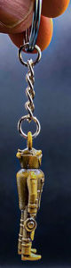 Gold-colored bomb technician keychain with a detailed figure and attached