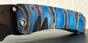Close-up of a Medford Knife Midi Marauder. Blue and black handle with