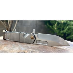 Silver Medford USMC Fighter flipper knife. Gray handle with textured grip.