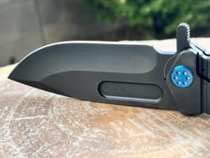 Black Medford USMC Fighter flipper knife. Visible blade and handle. Challenge Coin USA logo