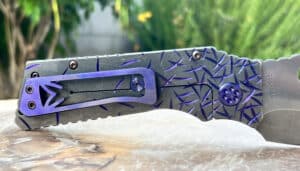 Medford TFF1 folding knife. Black and blue fade finish with textured blade. Visible pivot hardware. Challenge Coin USA