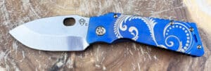 Blue Medford TFF1 Tactical Fighting Folder knife. Silver blade. Engraved floral design on blue handle. Challenge Coin USA