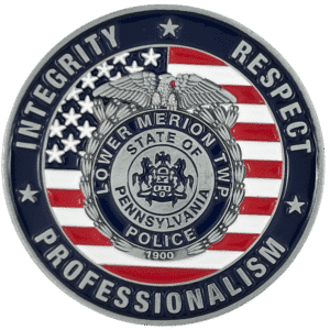 Challenge coin. Silver metal, blue and red design. Features Lower Merion Township seal and American flag. Text: INTEGRITY,